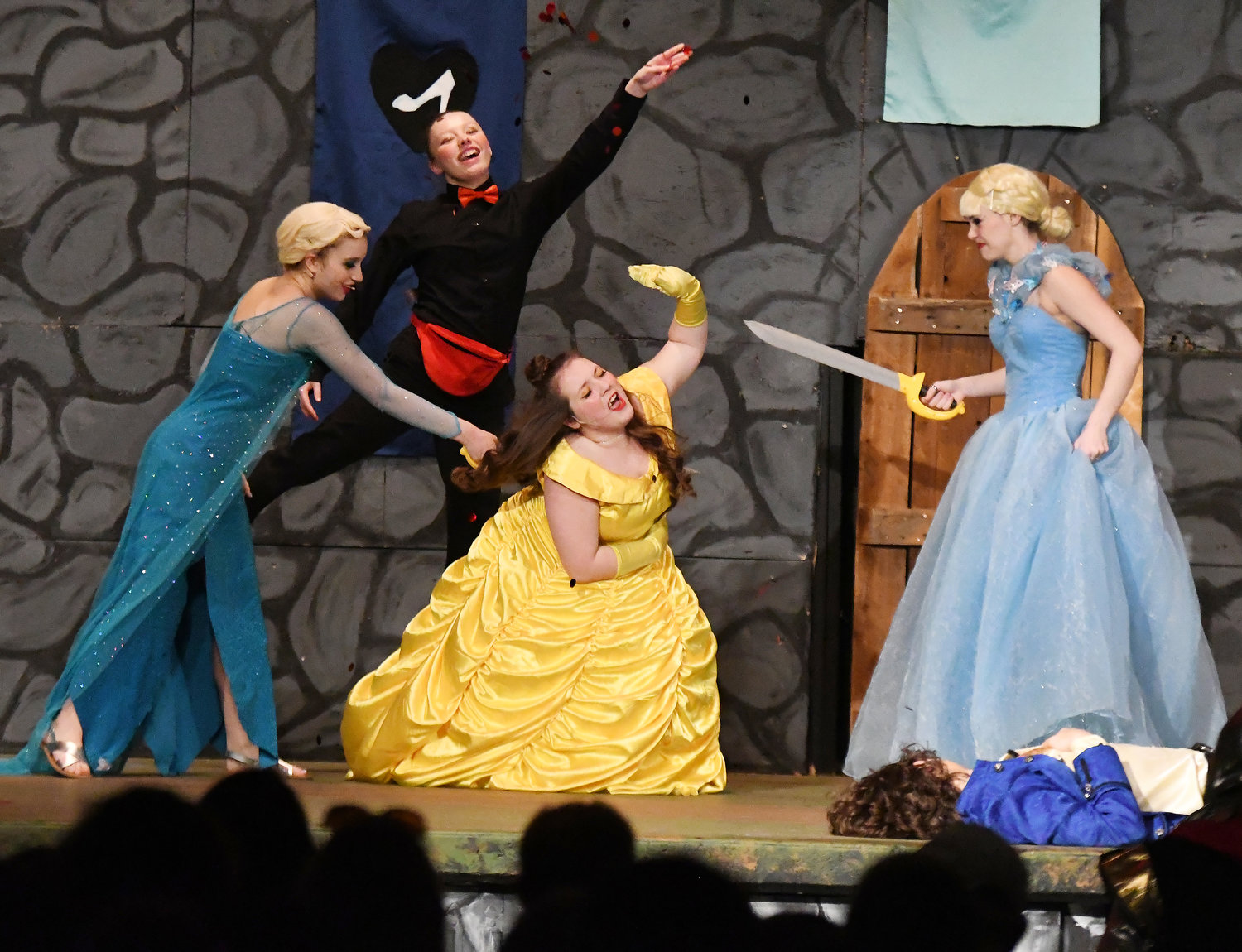 Shelby Malone, as the Snow Queen and Josie Wilka as Cinderella stab their sister Belle, played by Shelby Malone.