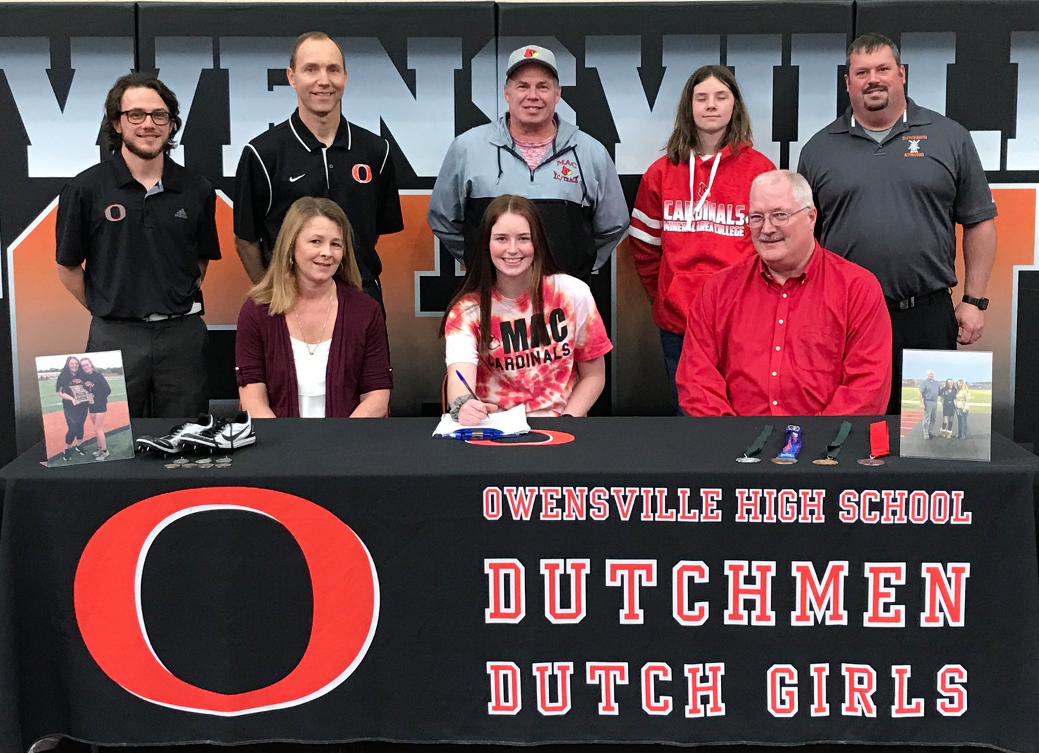 Kiera Finn (center, seated) signs her National Letter of Intent to continue her academic and athletic pursuits at Mineral Area College in Park Hills, Mo., for the Lady Cardinals Track and Field program surrounded by current and former coaches in addition to family members.