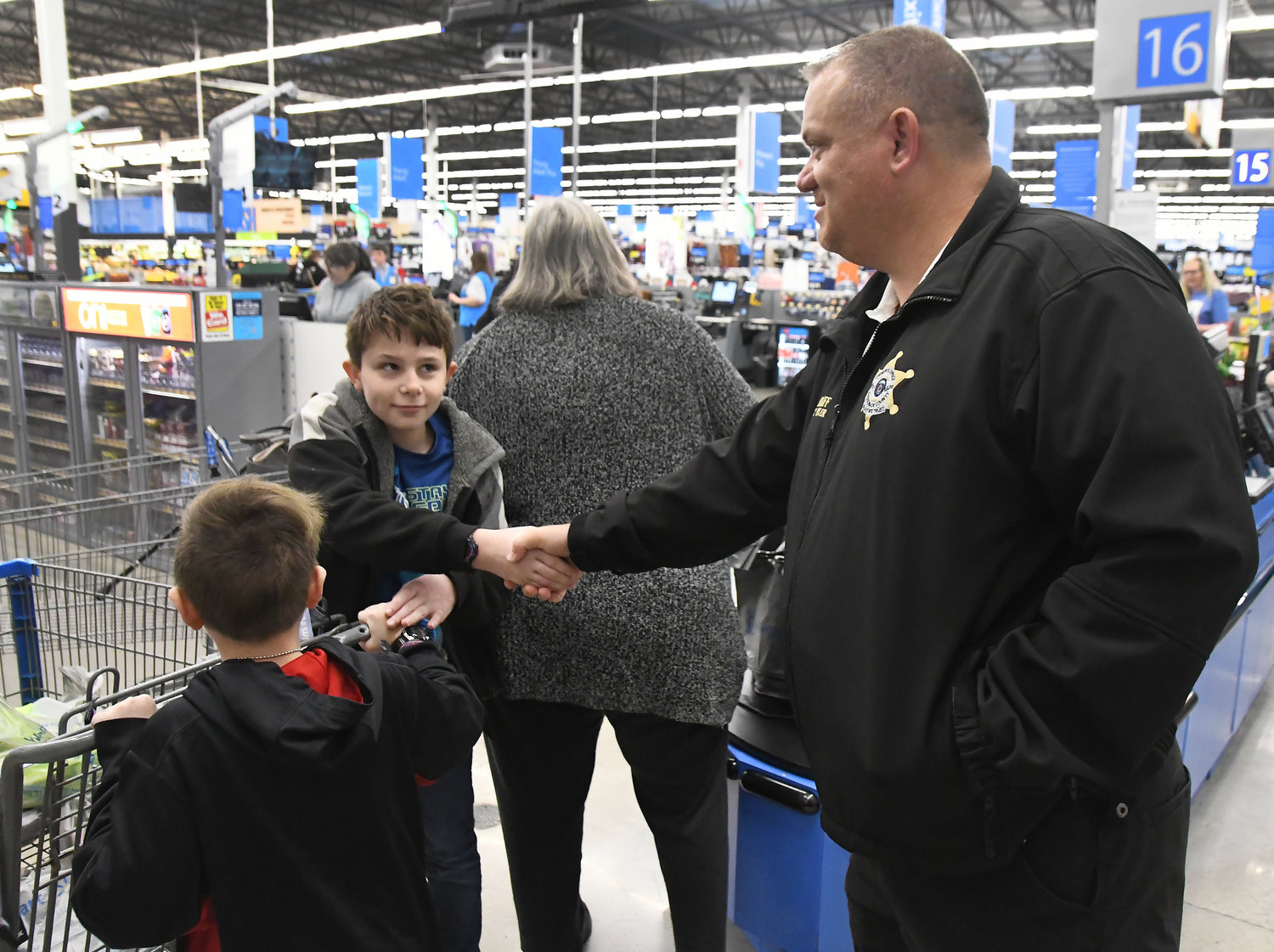 Participant Thomas Christie shakes hands with Gasconade County Sheriff Scott Eiler (right) as his brother, Tucker, looks on.