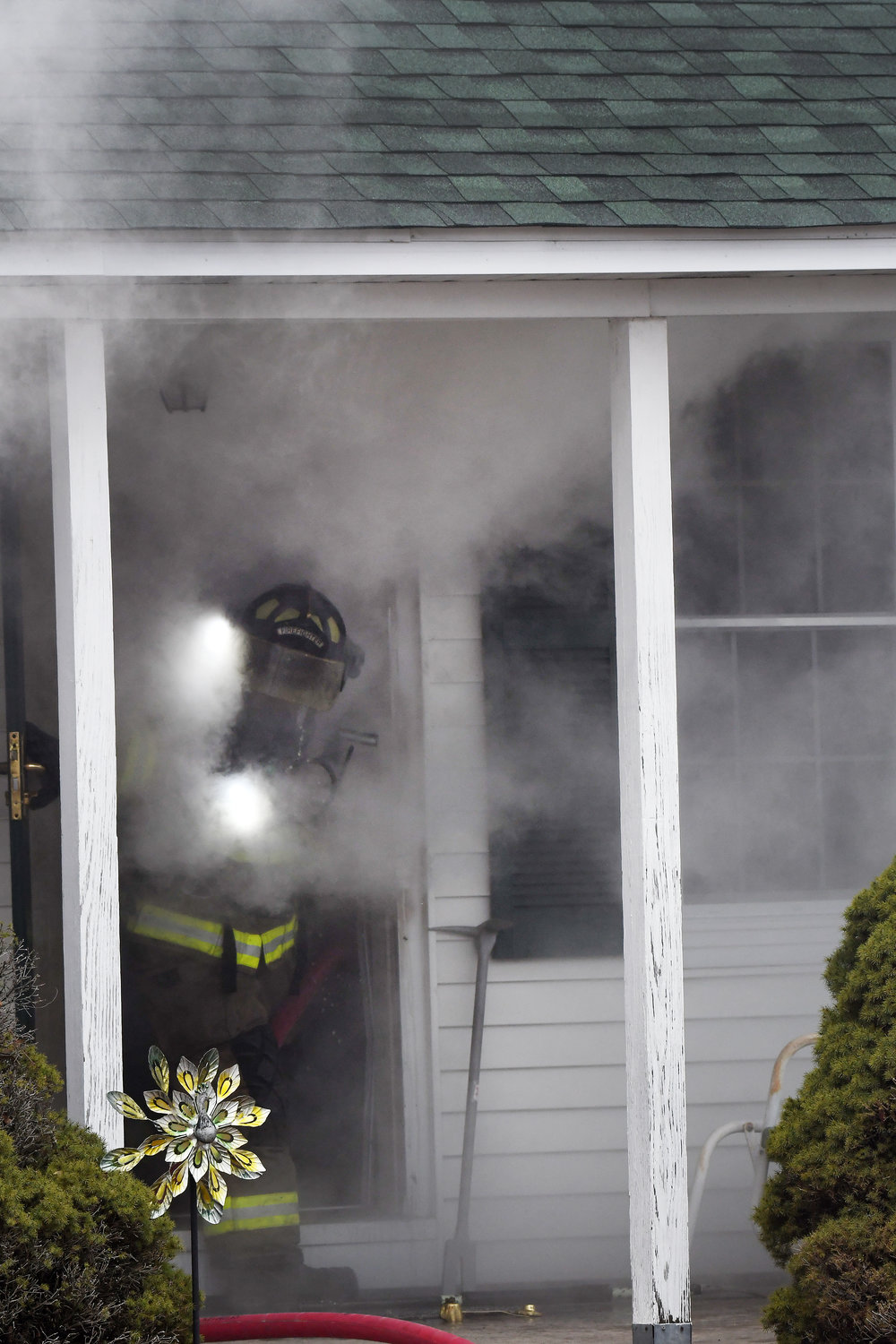 An Owensville fireman emerges Thursday afternoon from a smoke-filled residence on Seventh Street after conducting a search. Fortunately, the home was unoccupied at the time.